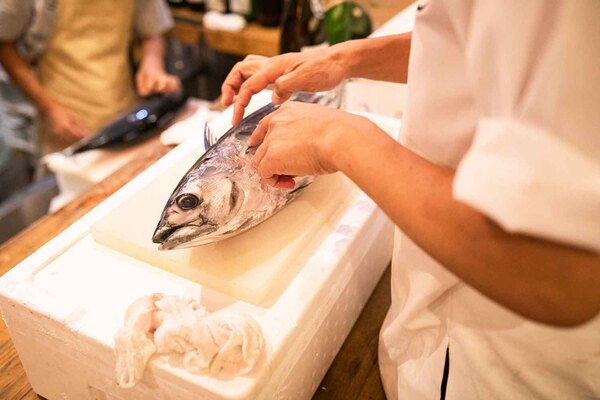 カツオのヒレを持ち上げて説明中